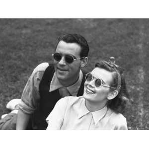  Couple Wearing Sunglasses Sitting on Grass, (B&W 