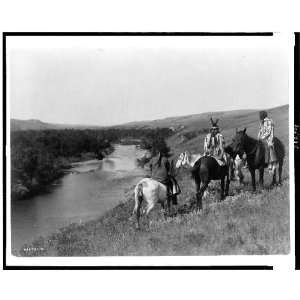  Three Piegan Indians,four horses on hill above river
