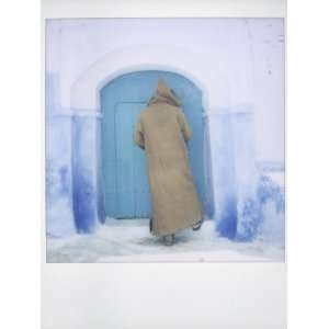  Polaroid of Man Wearing Djellaba Opening Blue Door to 